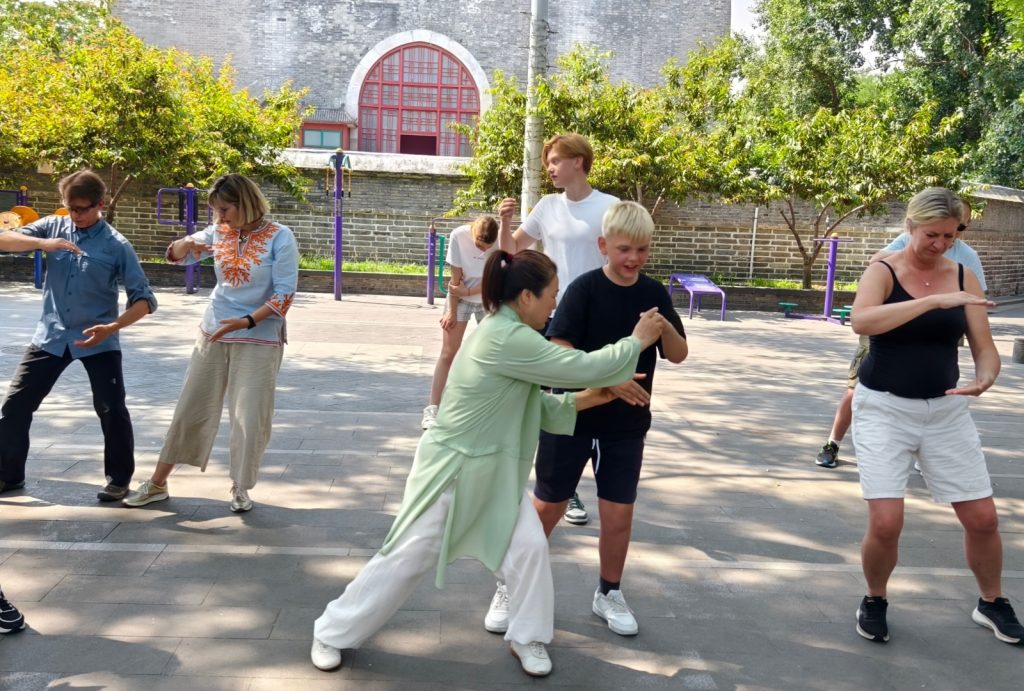 Tourists experience Tai Chi culture under the guidance of an instructor