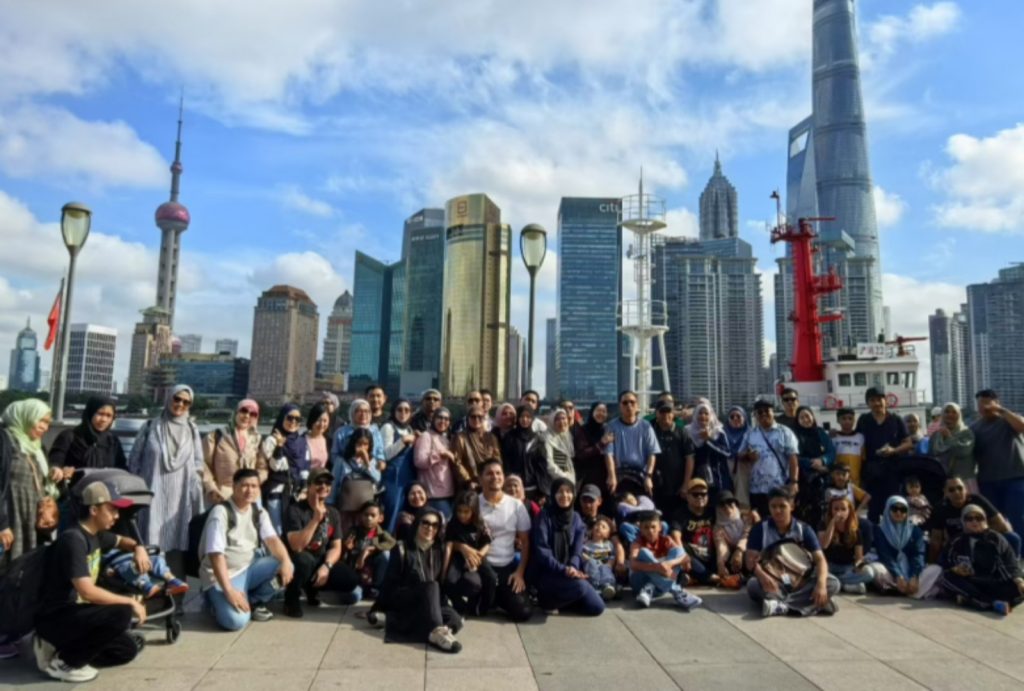 Large group of our Malaysian guests posing at the Bund in Shanghai with the iconic skyline