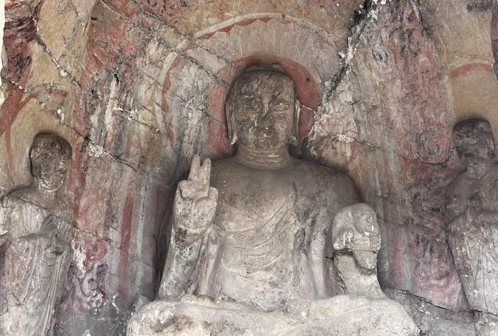 A Buddha making a V-sign with its hand