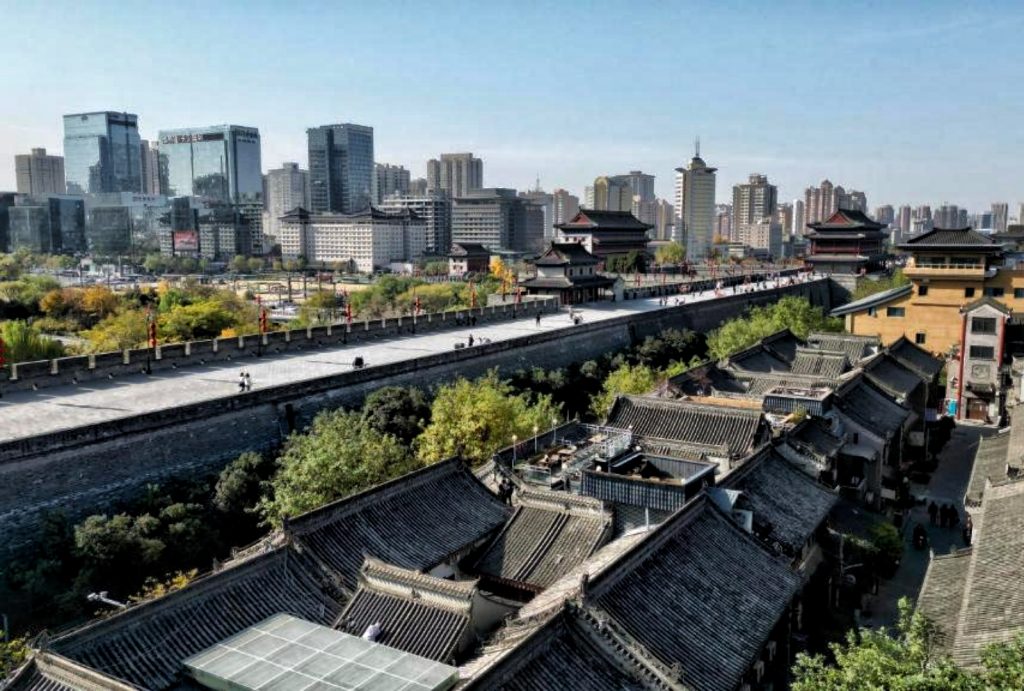 Xi'an City Wall walkway blending ancient and modern cityscape in autumn