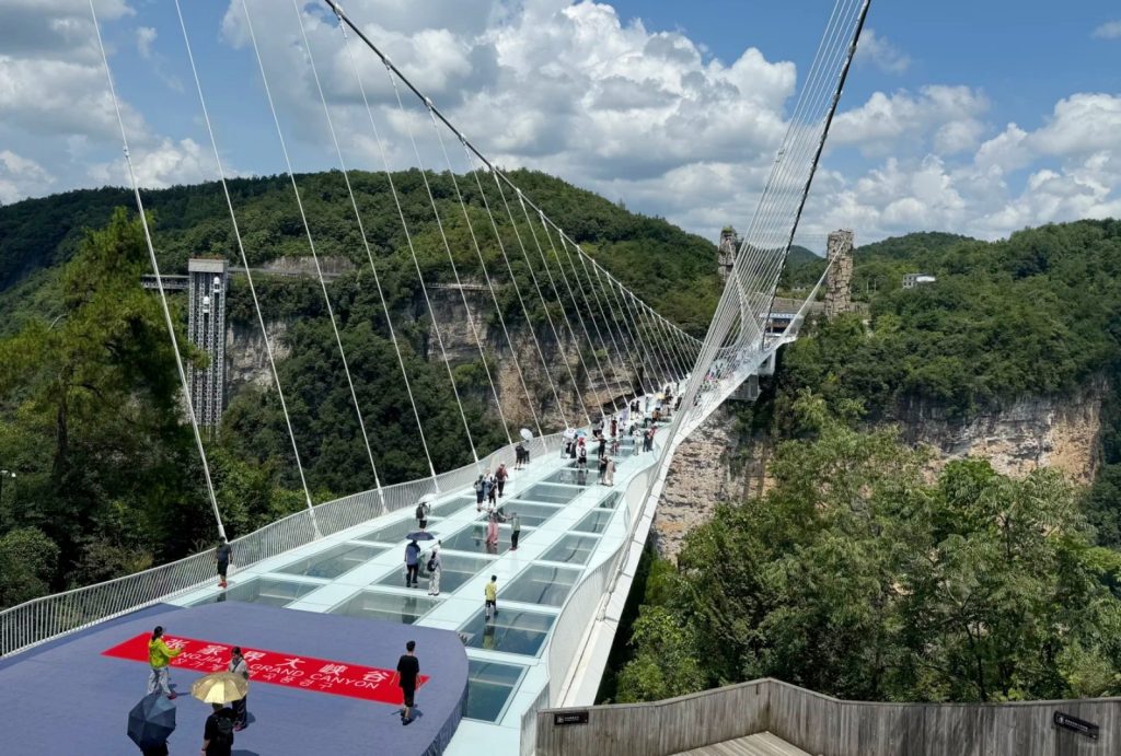 Visitors are walking across the Zhangjiajie Grand Canyon Glass Bridge